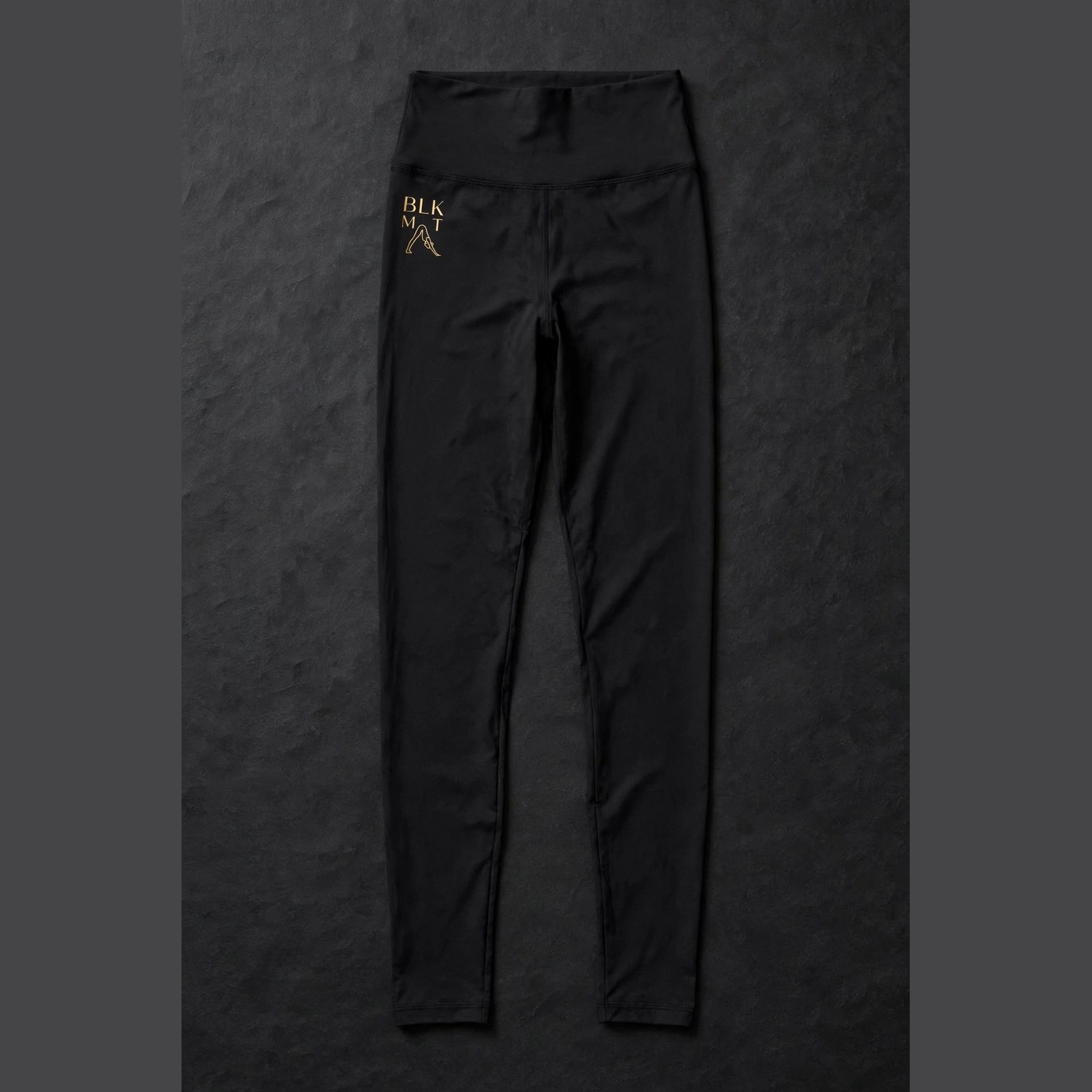 BLKMAT Essential Black Leggings — gold wordmark at the front hip