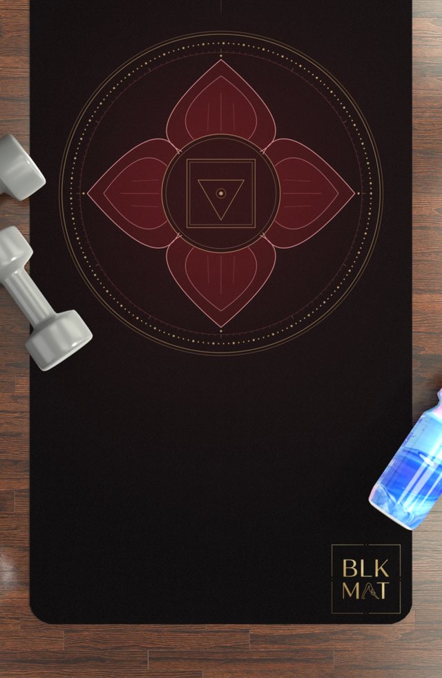 BLKMAT Root Chakra yoga mat, flat lay on a wood floor