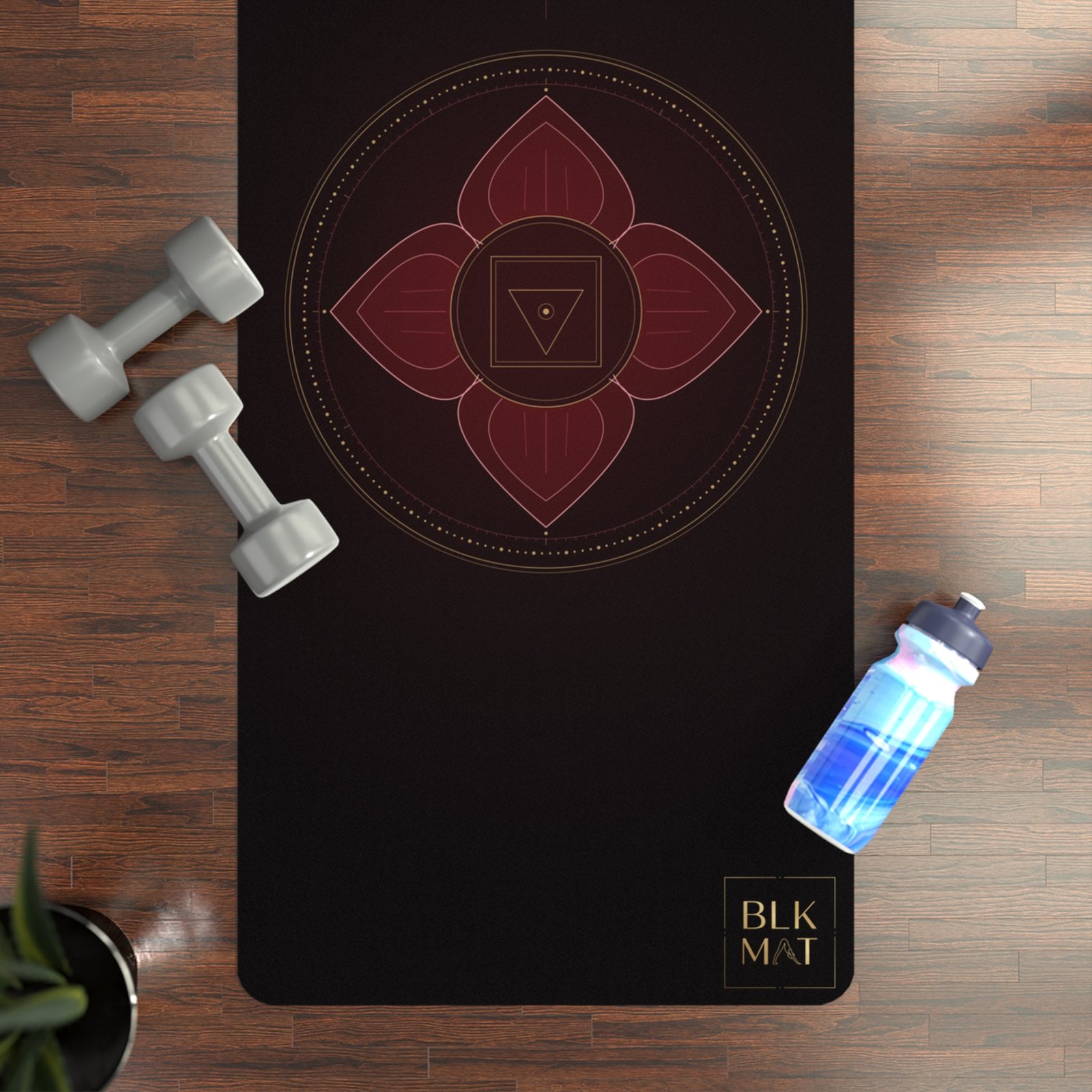 BLKMAT Root Chakra yoga mat, flat lay on a wood floor
