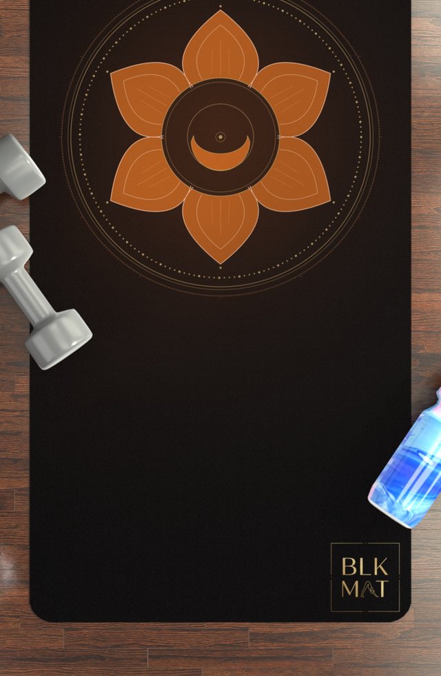 BLKMAT Sacral Chakra yoga mat, flat lay on a wood floor