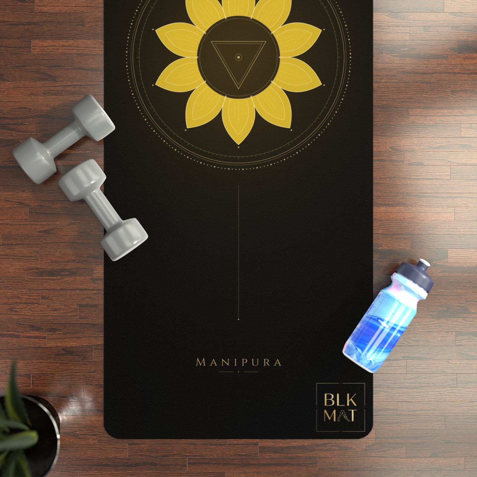 BLKMAT Solar Plexus Chakra yoga mat, flat lay on a wood floor