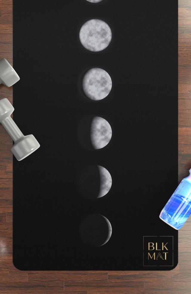 BLKMAT Midnight Moon Phases yoga mat, flat lay on a wood floor
