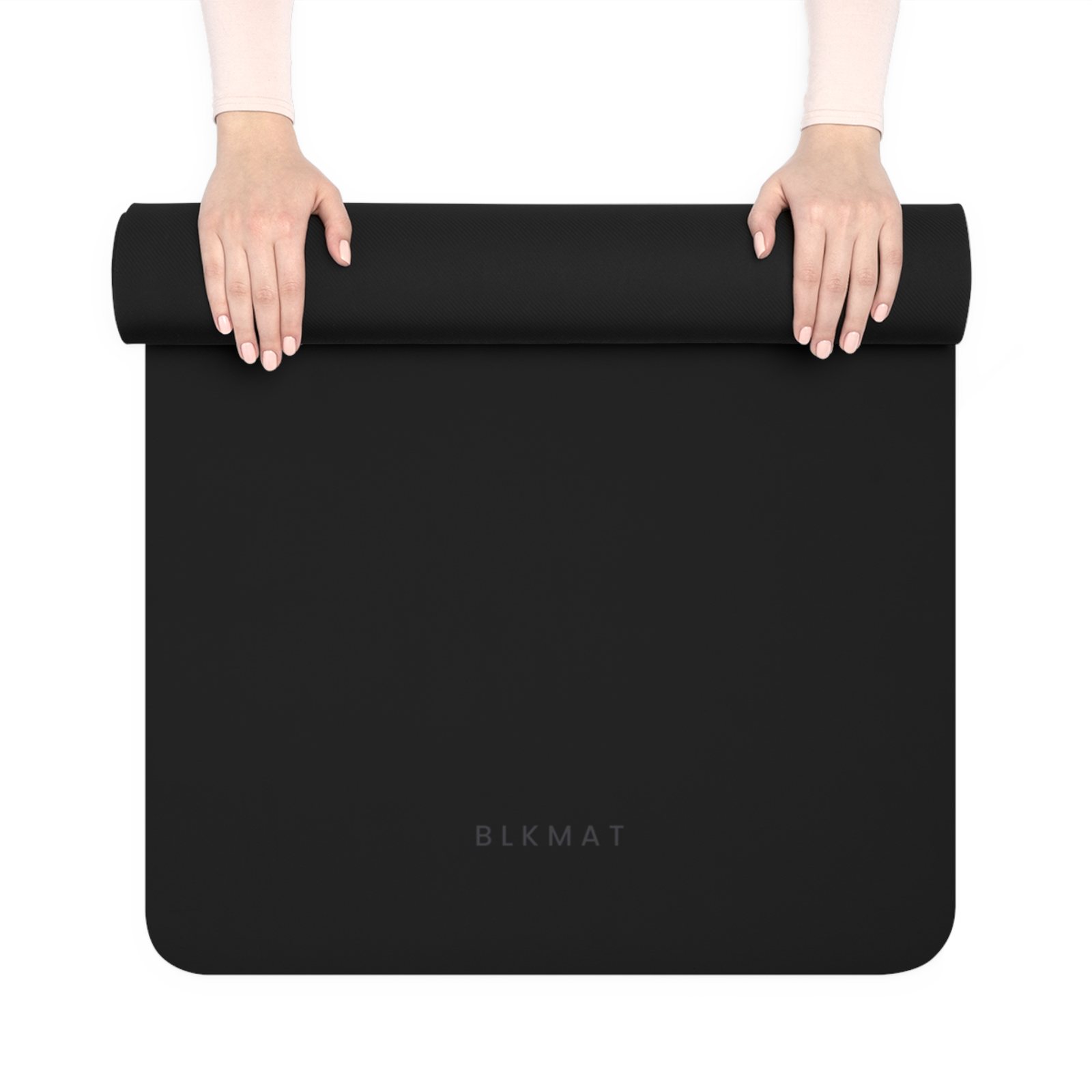 BLKMAT Plain Black yoga mat, held up and partly rolled