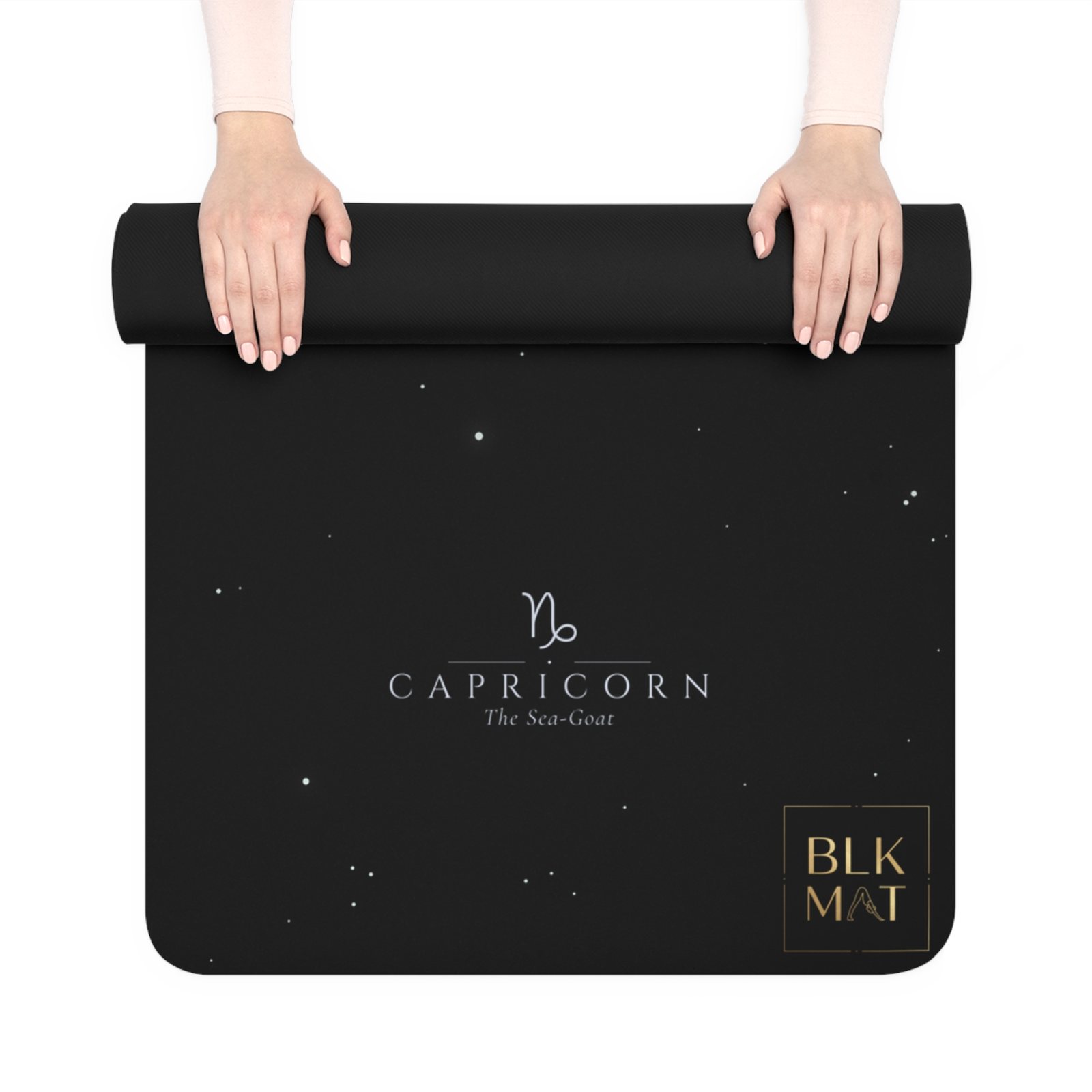 BLKMAT Capricorn Constellation yoga mat, held up and partly rolled