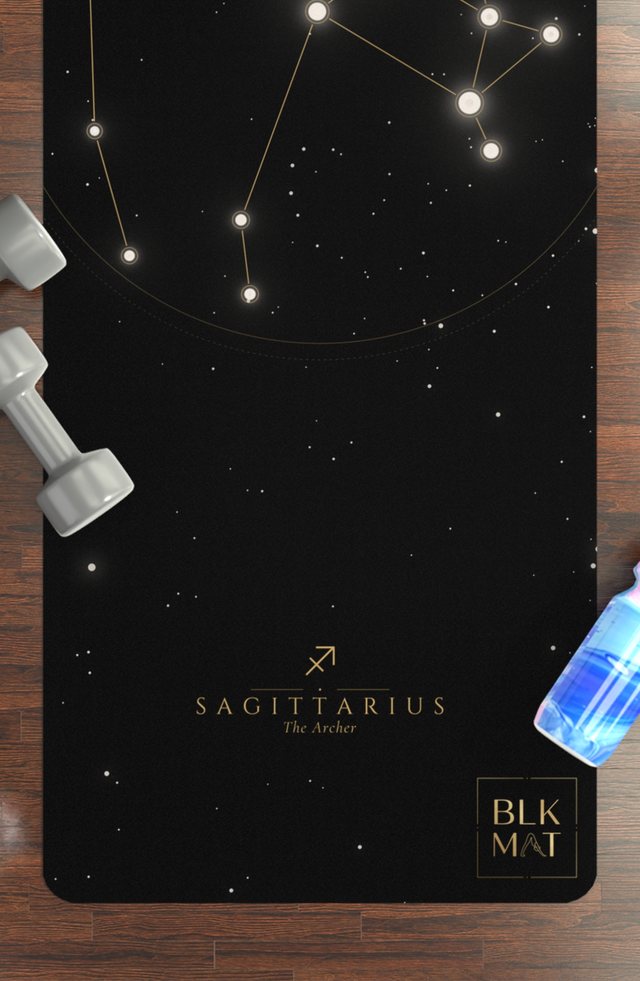 BLKMAT Sagittarius Constellation yoga mat, flat lay on a wood floor