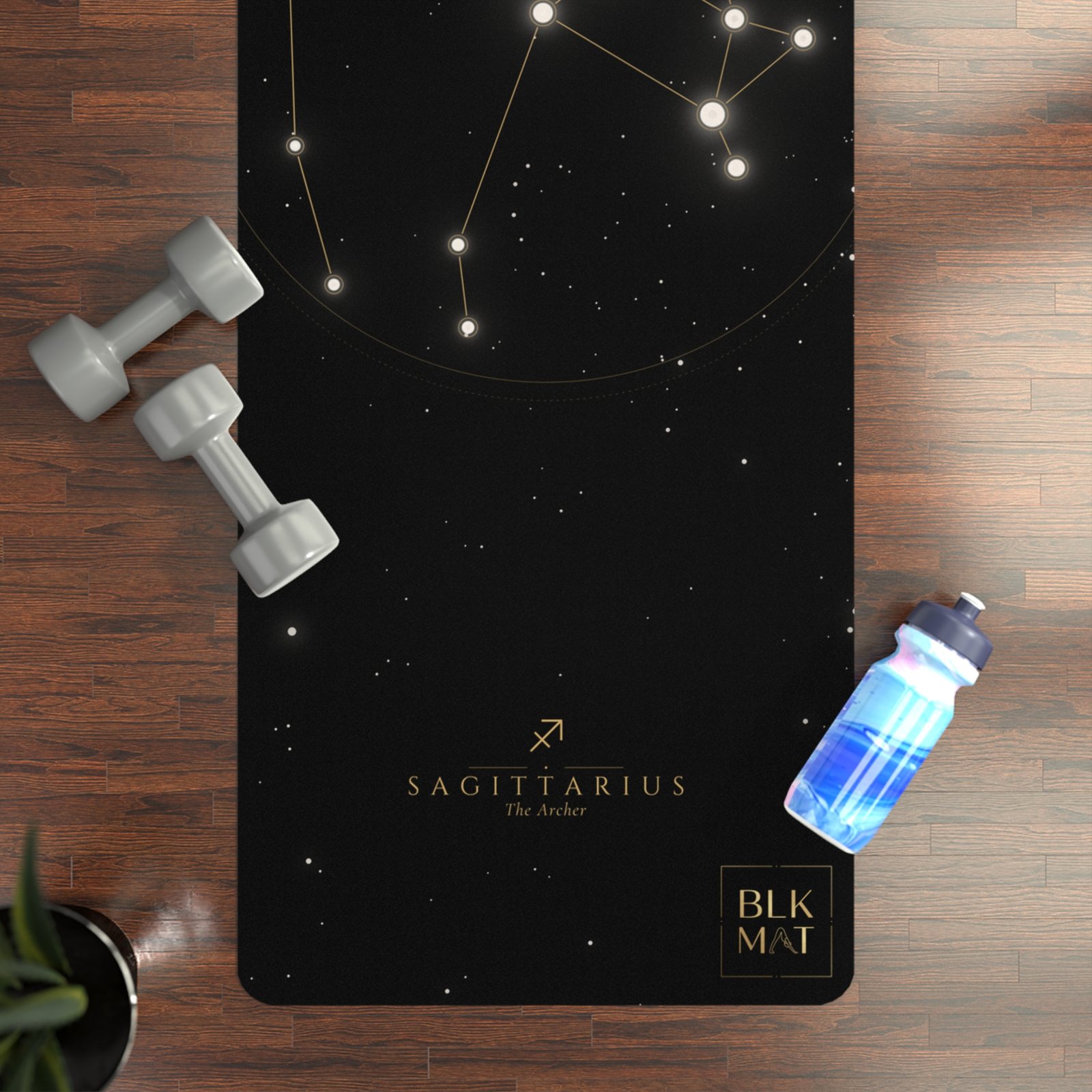 BLKMAT Sagittarius Constellation yoga mat, flat lay on a wood floor