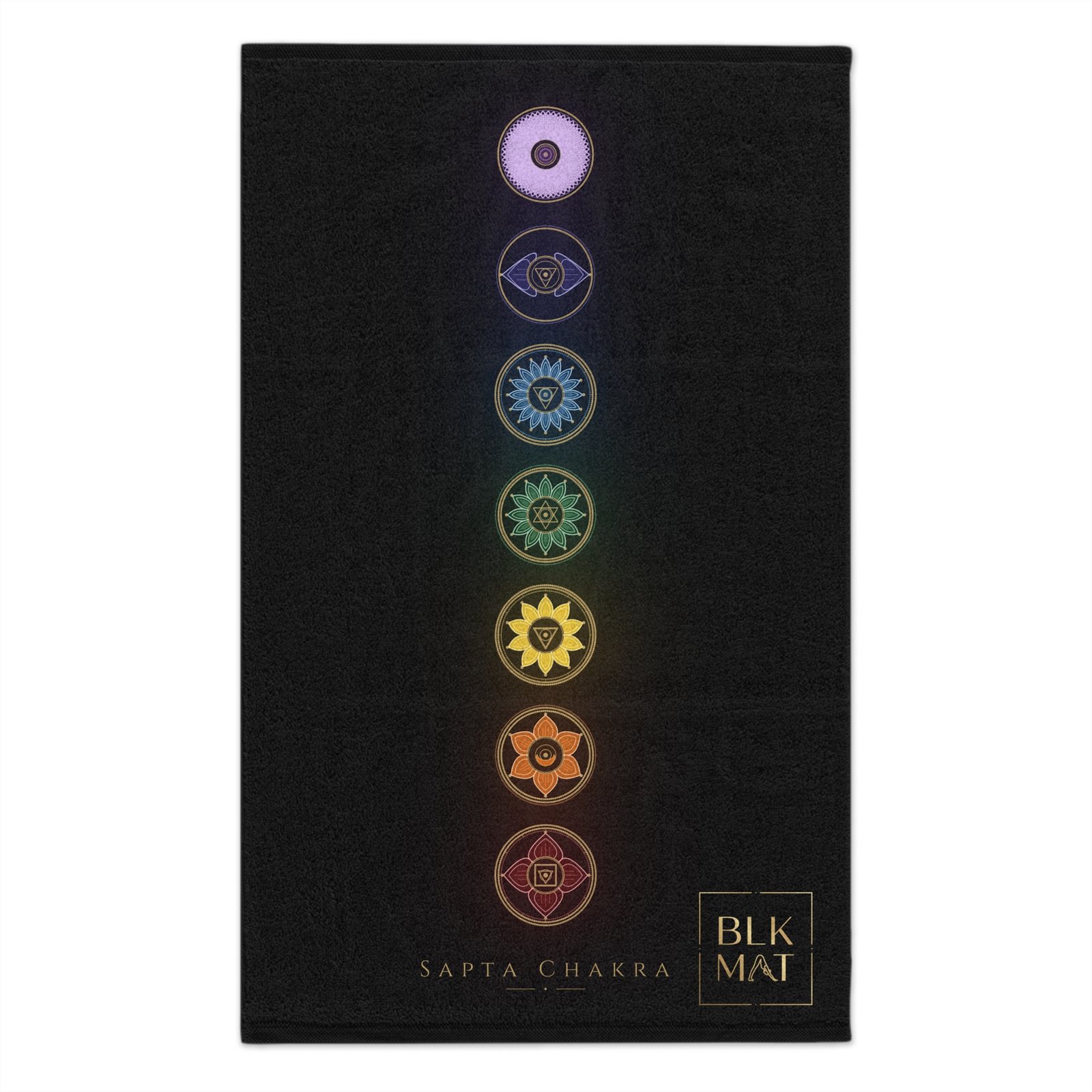 Small black gym towel with seven rainbow-colored chakra emblems stacked down its length, the caption Sapta Chakra, and a small gold BLKMAT logo in the bottom corner.
