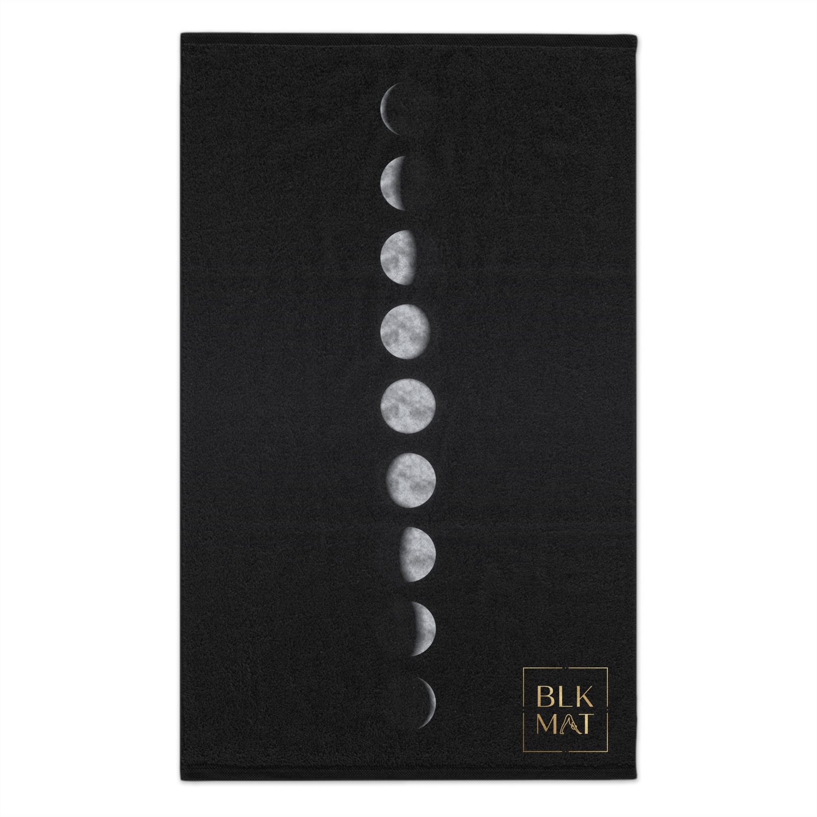 Small black gym towel with a vertical line of nine silver moon phases, new to full and back, and a small gold BLKMAT logo in the bottom corner.