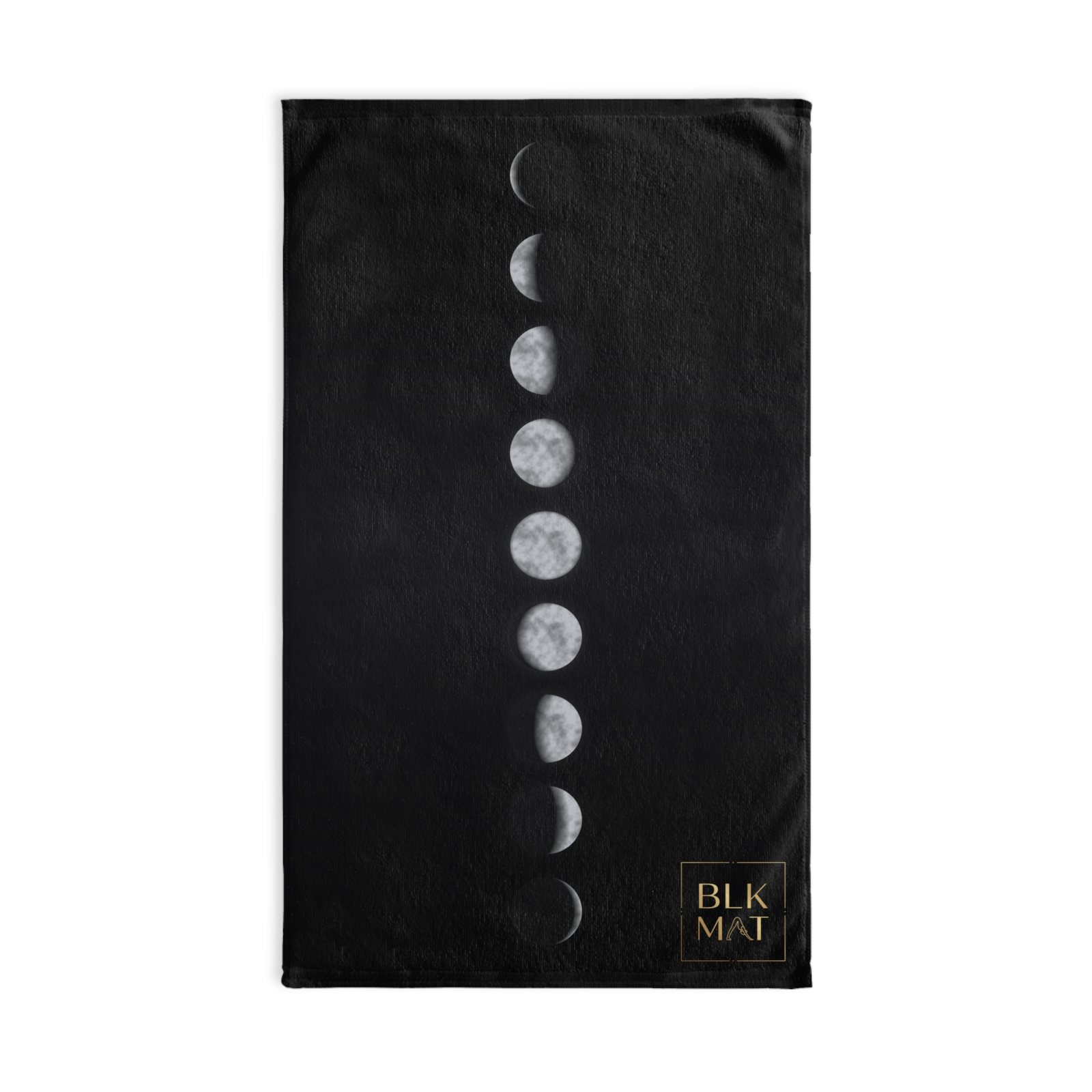 Black hand towel with a vertical line of nine silver moon phases, new to full and back, and a small gold BLKMAT logo in the bottom corner.